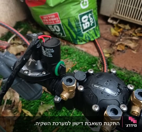 שסתום השקיה עם צינורות ומחבר פליז בגינה